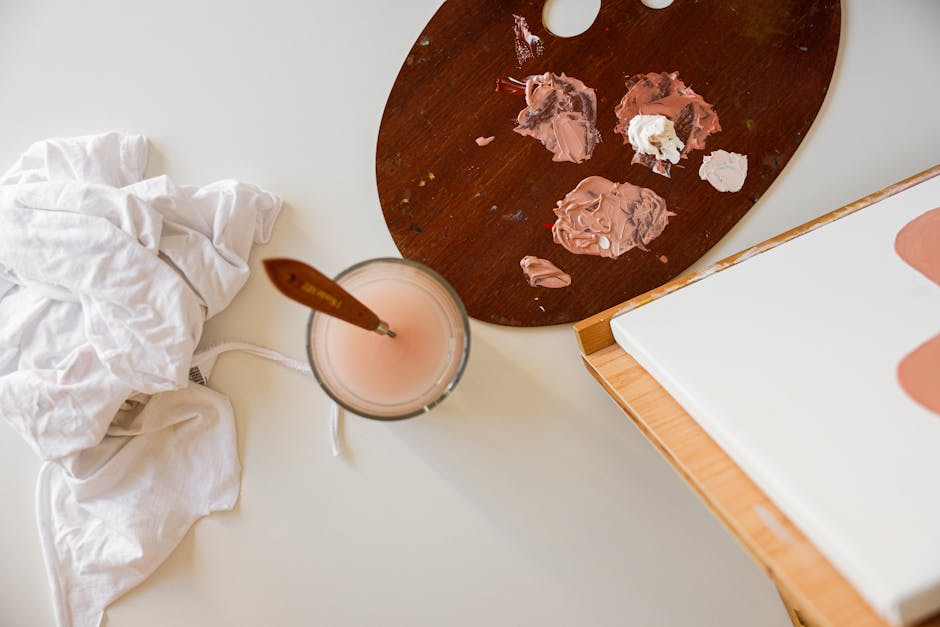 Top view of a painting setup with paint palette, brushes, and canvas, perfect for creative projects.