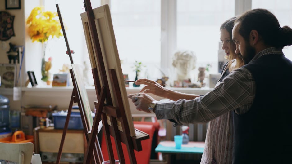 Two artists collaborating in a sunlit studio, creating art together.