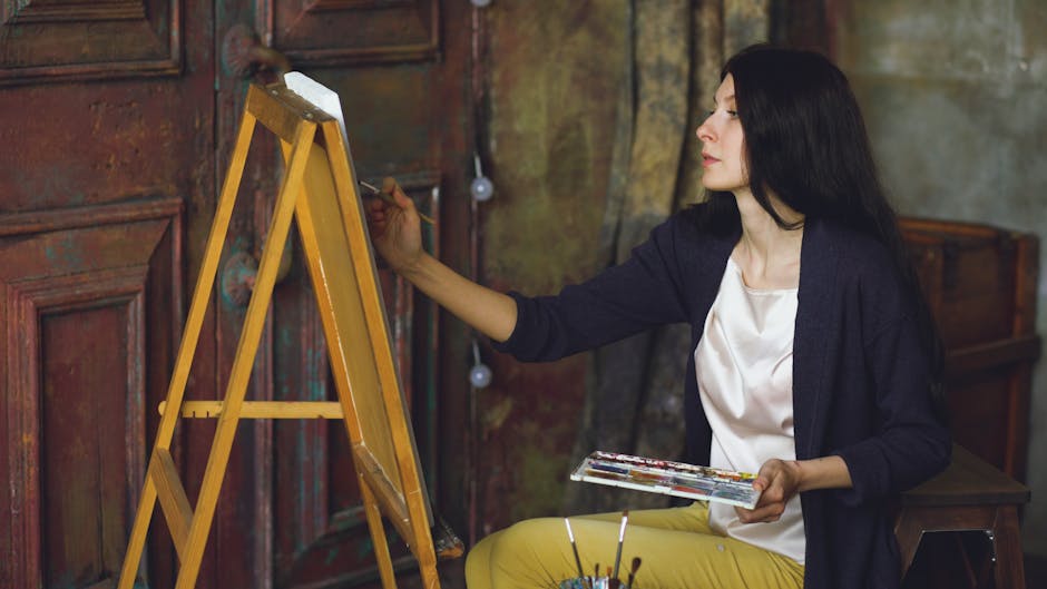 Female artist focused on painting a canvas indoors, showcasing creativity.