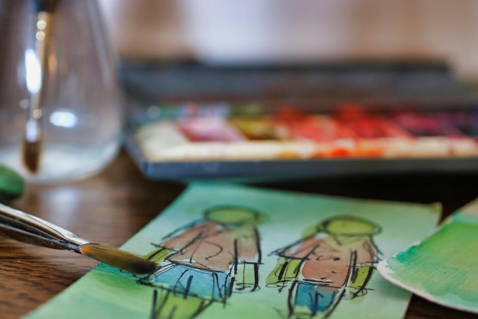 Close-up of watercolor artwork with paintbrushes and palette, showcasing creativity indoors.