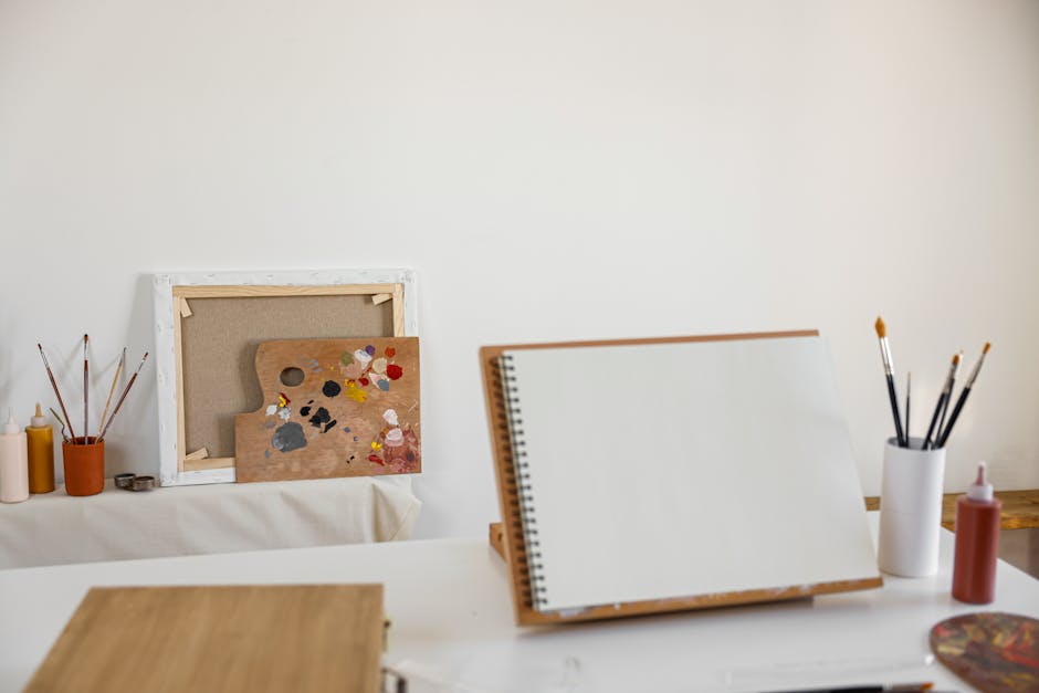 Cozy art studio setup with canvas, painting supplies, and blank notebook ready for creativity.